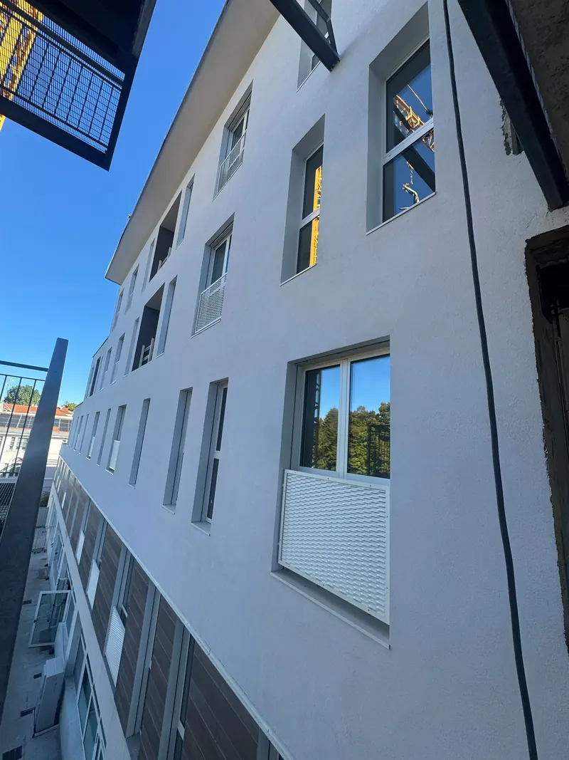 White façade of an apartment block with many windows