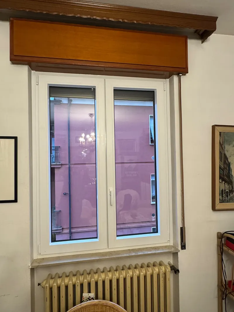 White two-leaf window under a wooden shutter box
