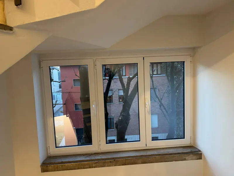 White three-leaf window in a stairwell