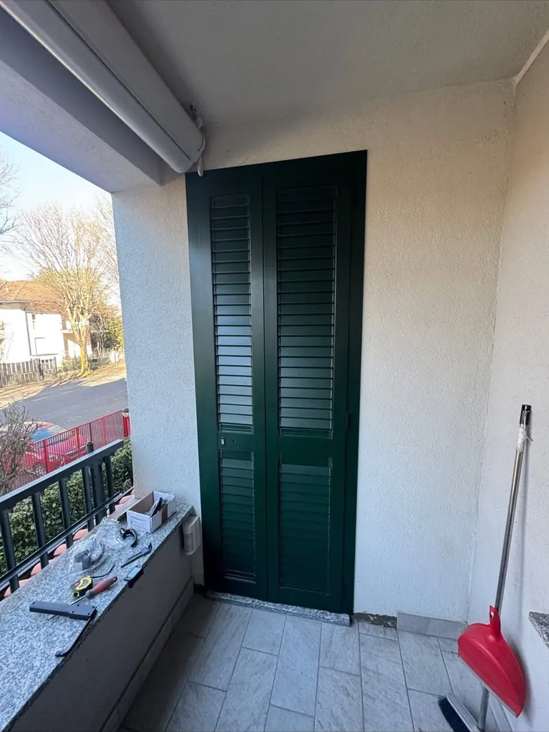 Persiana verde chiusa su una porta finestra del balcone